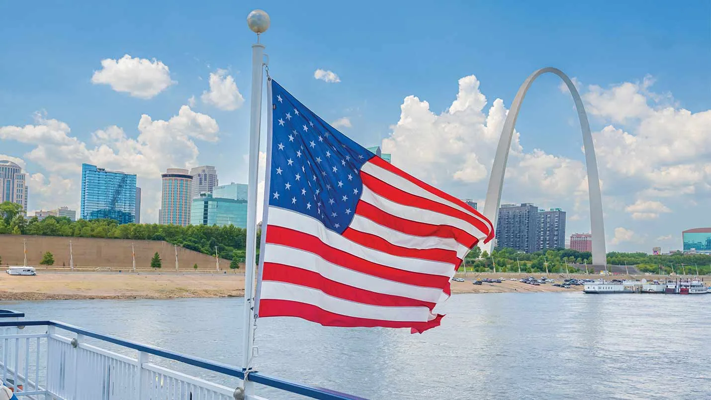 Flag at a ship's stern with the St. Louis skyline beyond