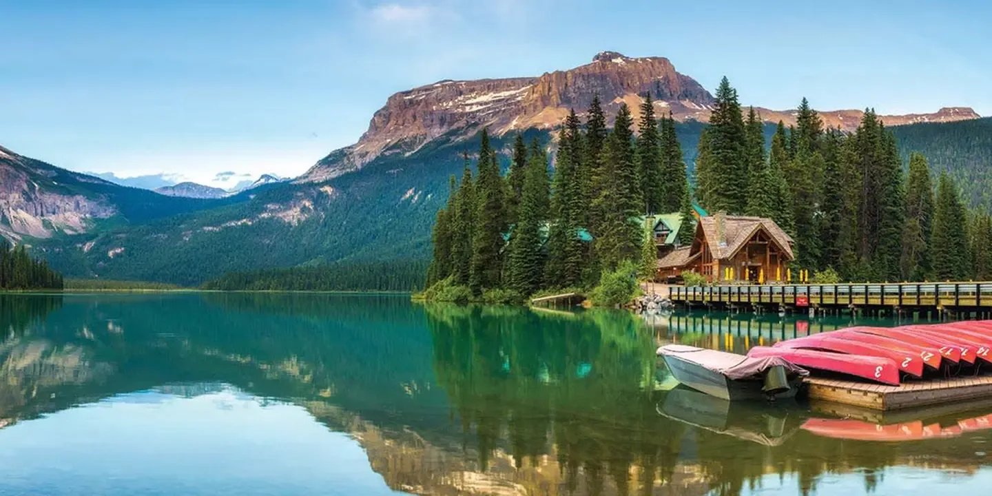 Lakeside lodge beneath forested mountains