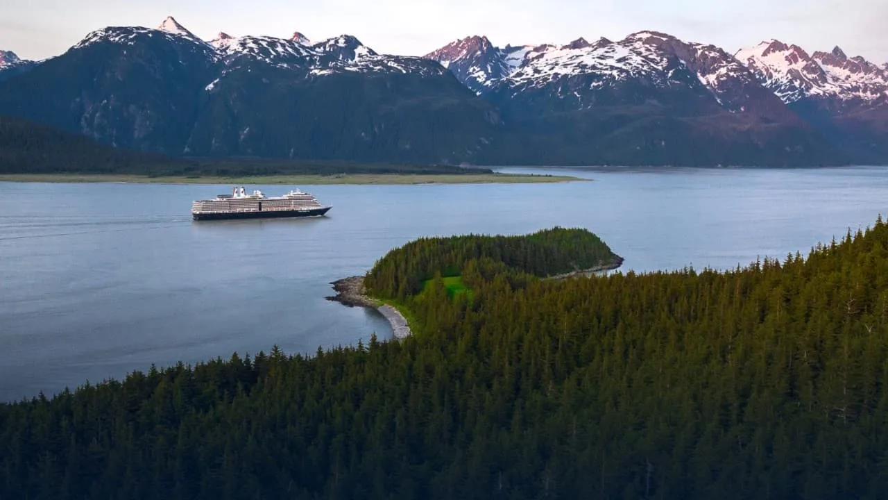 Ship in an Alaskan inlet beneath snow-covered mountains