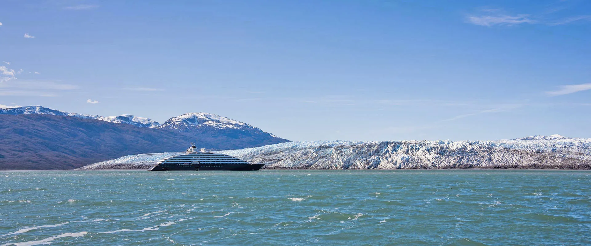 Ship beneath snow-covered mountains